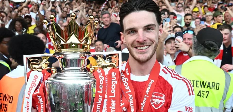 Player celebrating with Premier League trophy in crowd