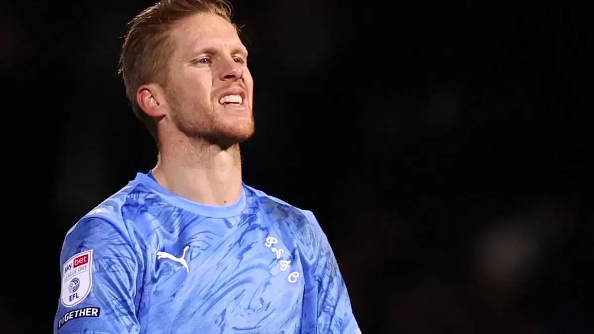 Goalkeeper in blue jersey during match action