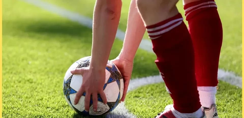 Player placing ball for a set piece on field