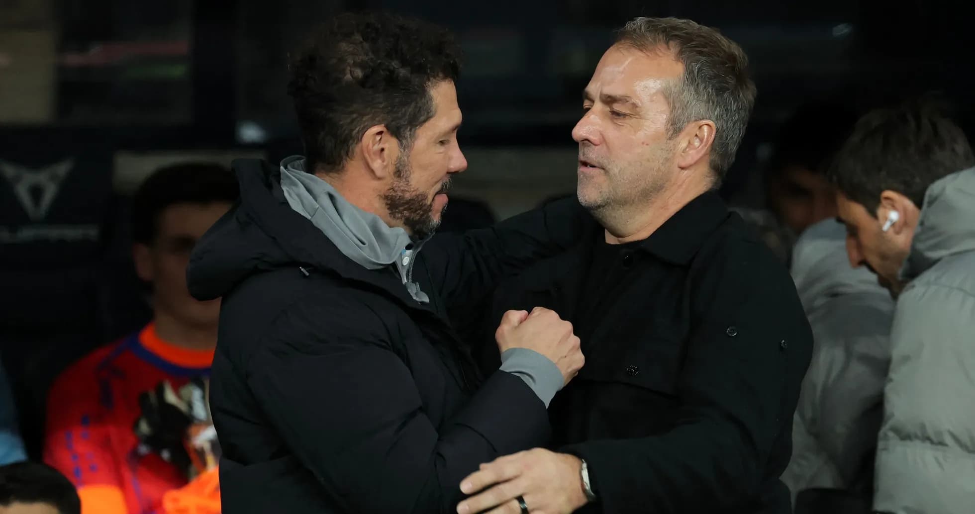 Two football managers greeting each other on the sidelines