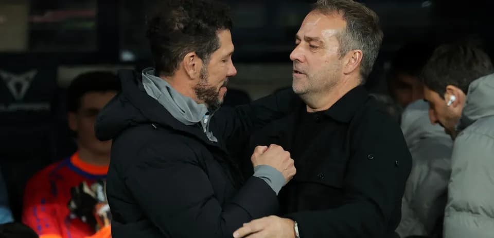 Two football managers greeting each other on the sidelines