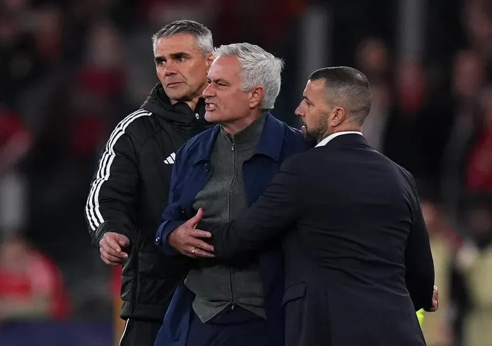 Coach being restrained by staff during heated moment