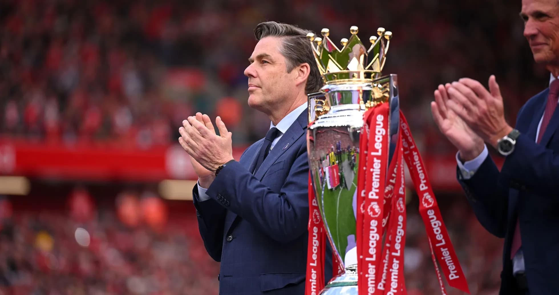 Man applauding near Premier League trophy presentation