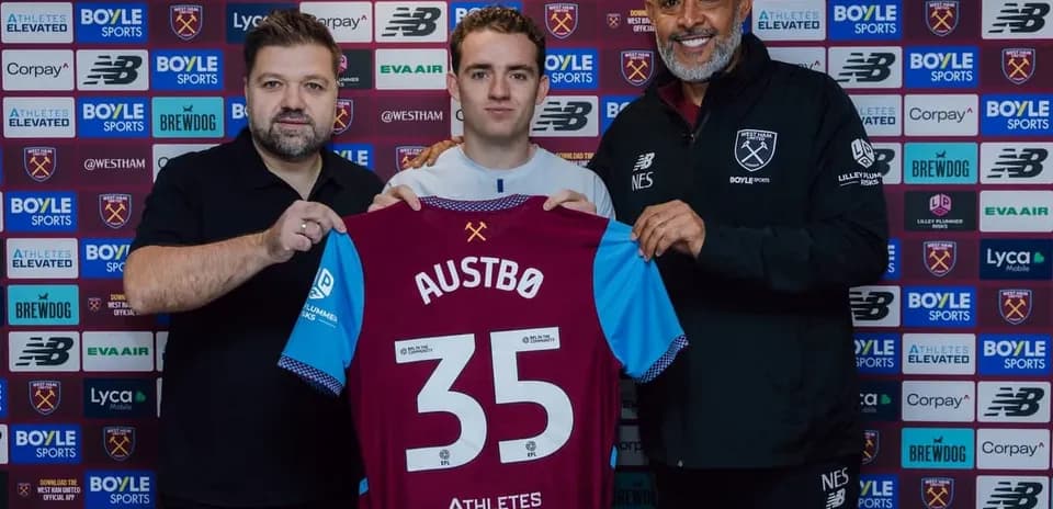 New player holding jersey at signing announcement
