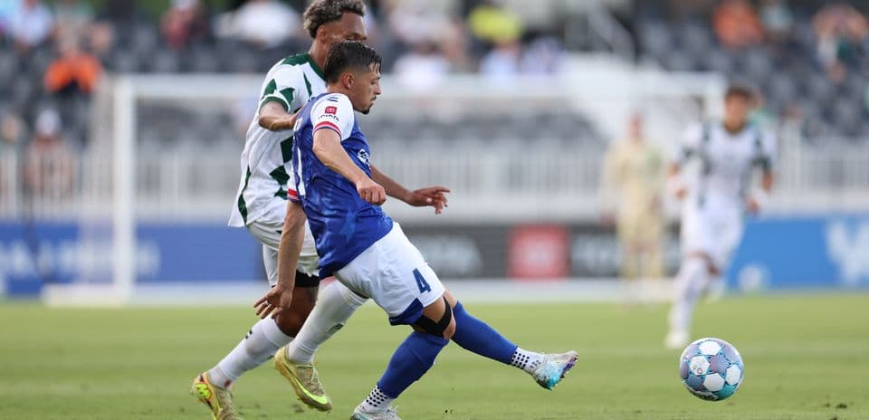 Player tackling for the ball in football match