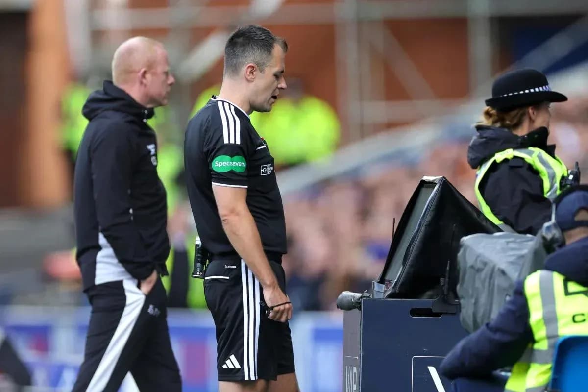 Referee consulting VAR monitor during match decision