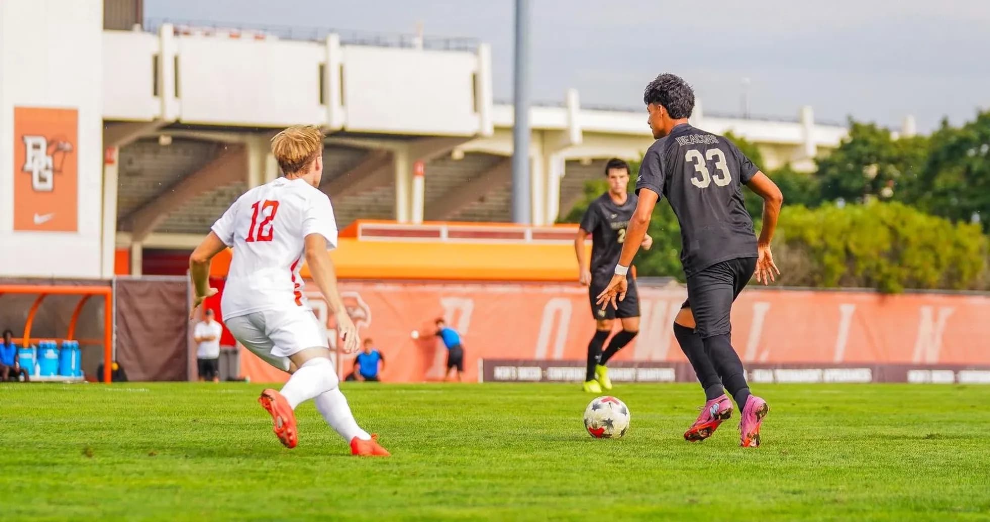 Player 33 dribbling the ball past opponent 12