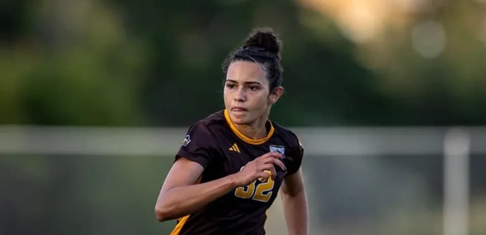 Player in brown jersey running on soccer field