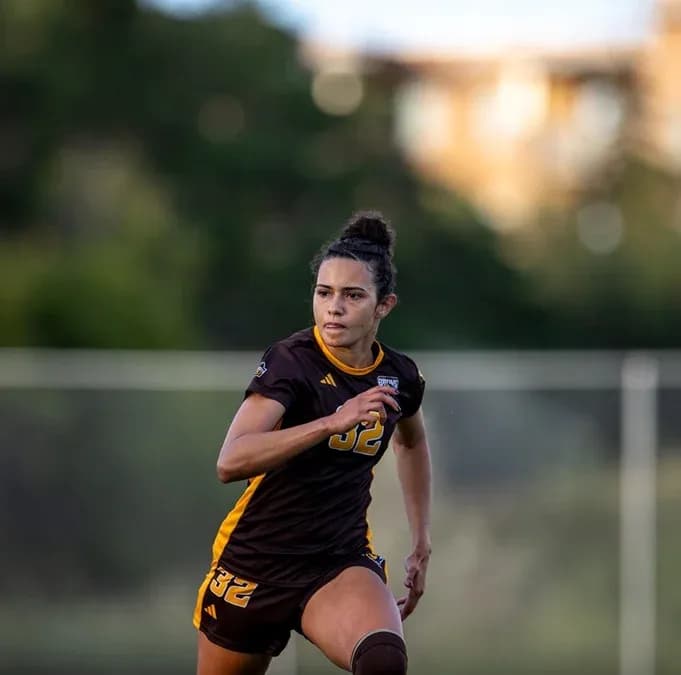 Player in brown jersey running on soccer field