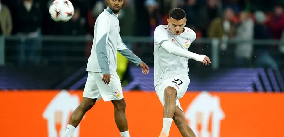 Player kicking ball while teammate observes during warm-up