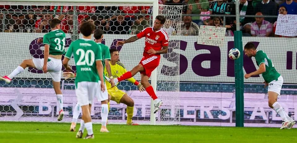 Goalkeeper attempts to block header during match