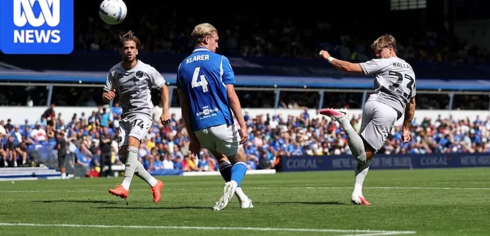 Player kicking ball during football match action