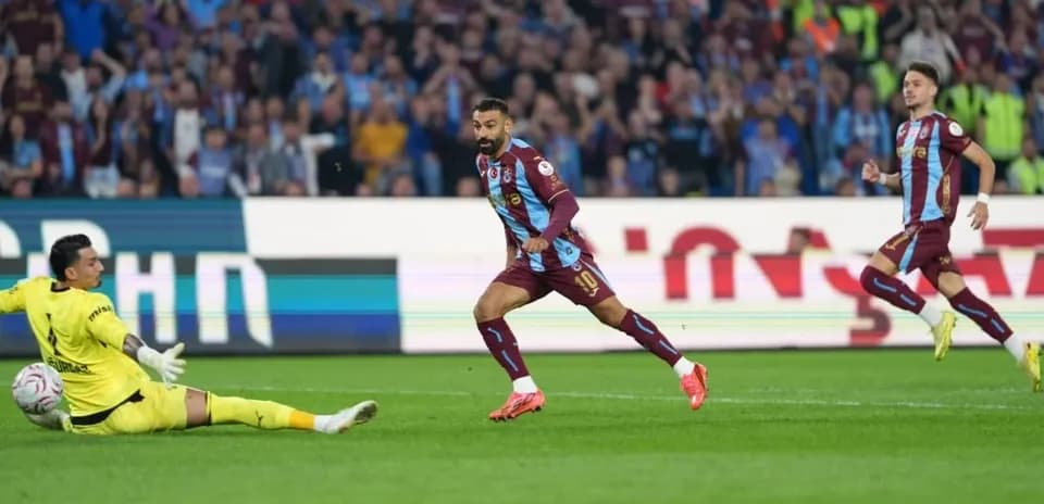 Player scoring past the goalkeeper during match