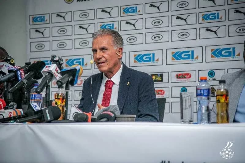 Manager speaking at press conference with microphones