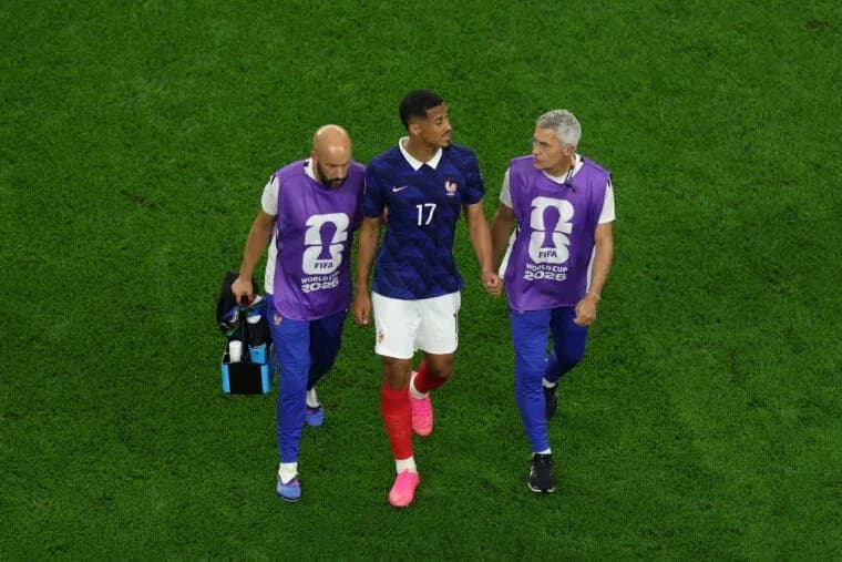 Player being assisted off the field by staff