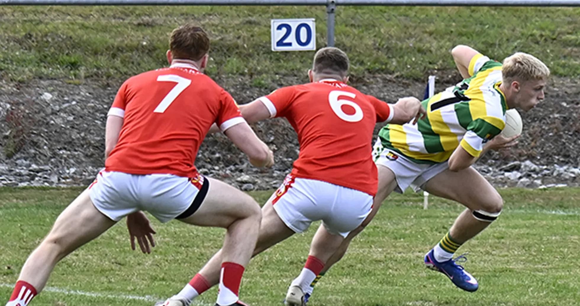 Player in green and yellow evading two red opponents