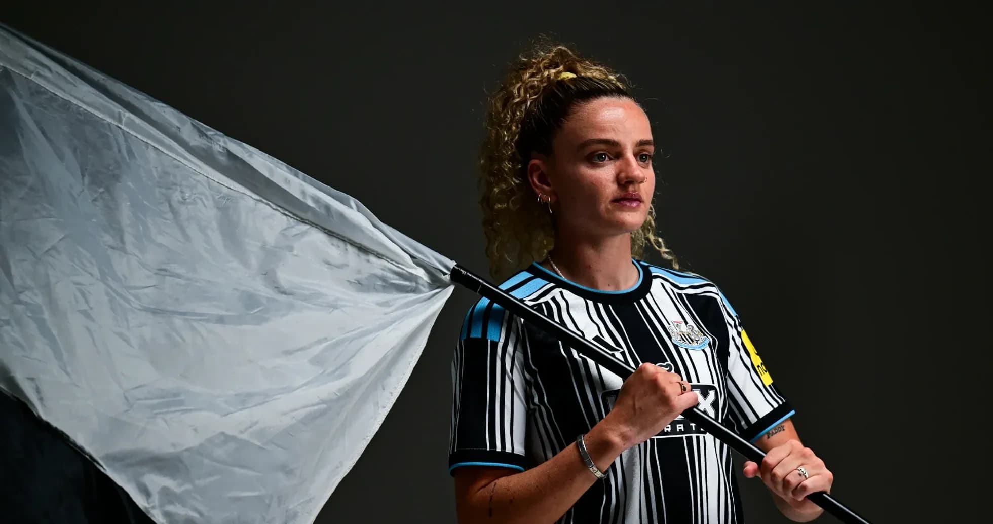 Player holding a flag wearing Newcastle kit