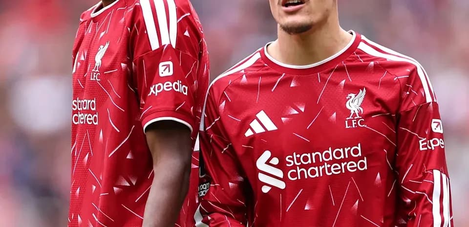 Two Liverpool players in red kits on the field