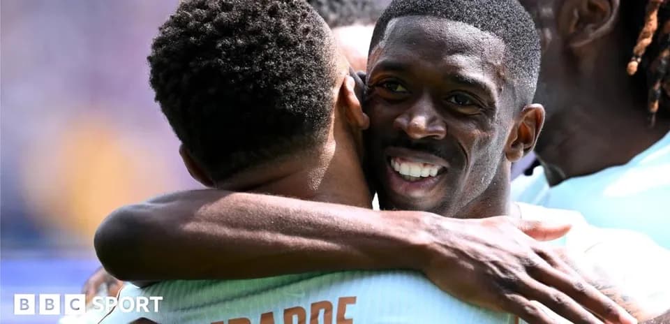 Players celebrating a goal with a hug