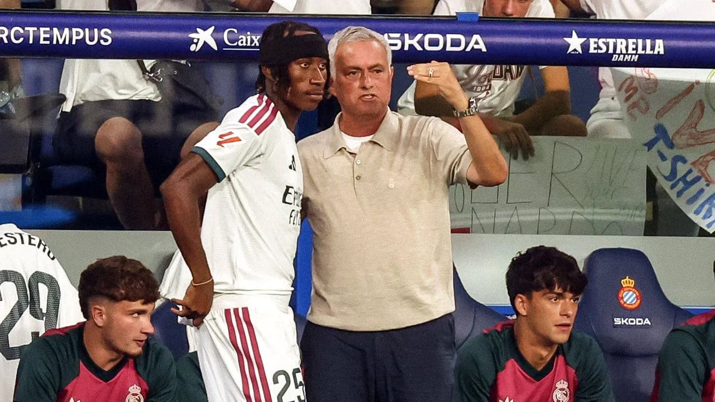 Coach discussing strategy with player on bench