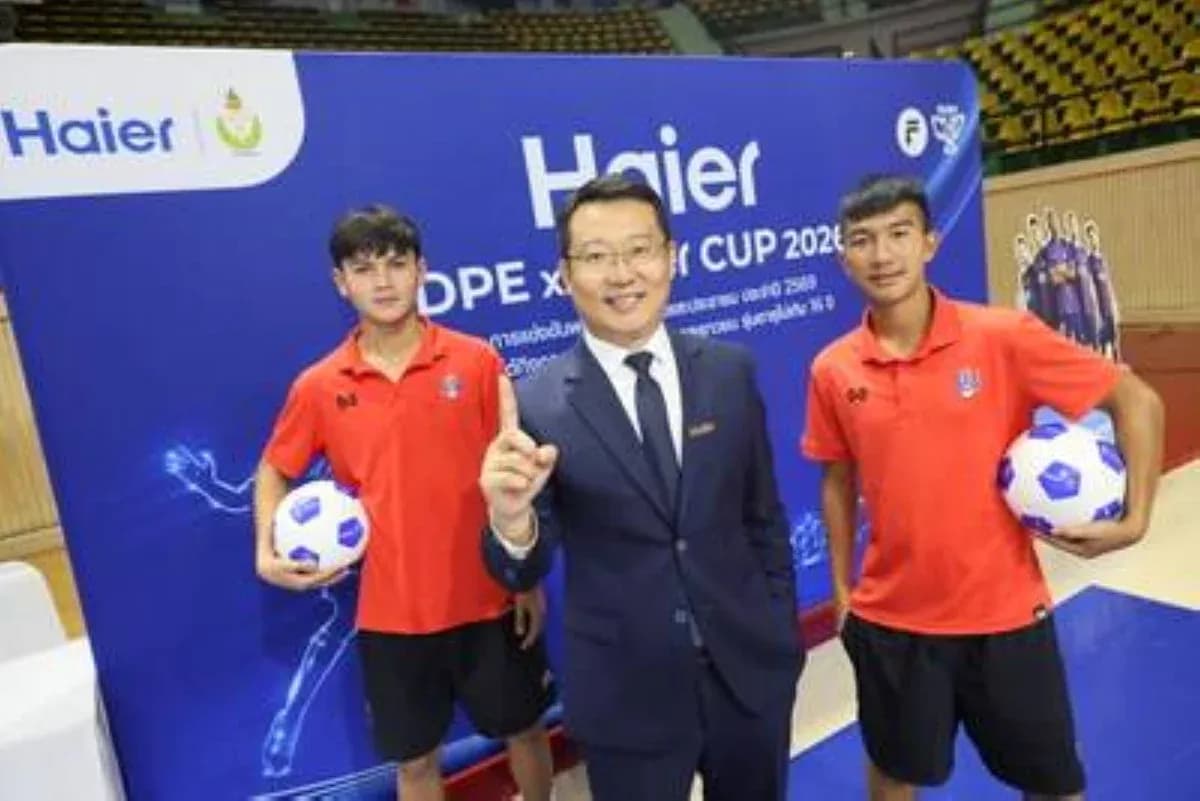 Two young football players with a businessman at event