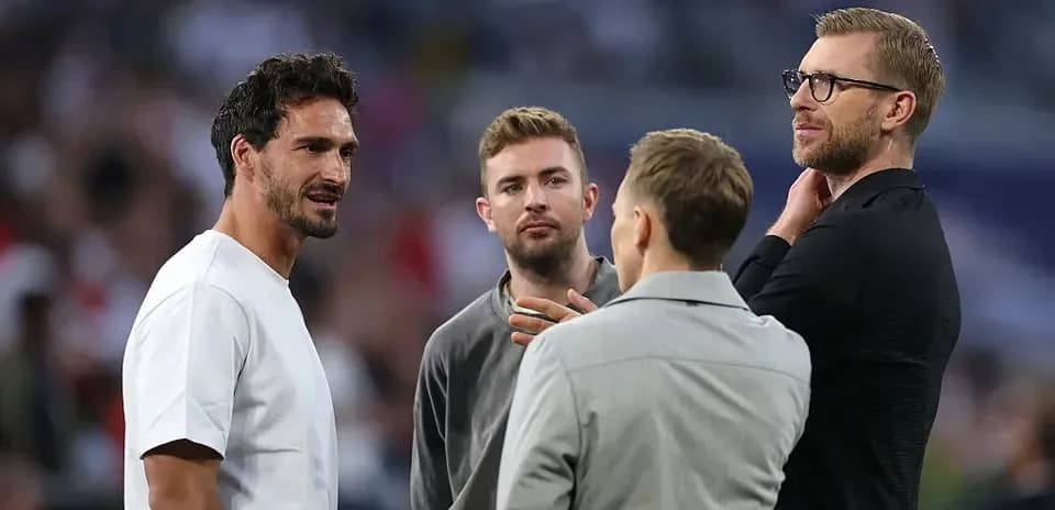 Four men discussing on the pitch before match