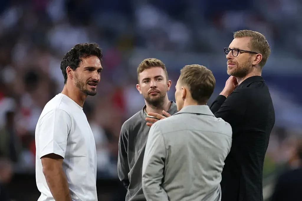 Four men discussing on the pitch before match