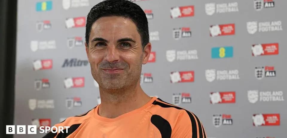 Coach smiling during a press conference backdrop