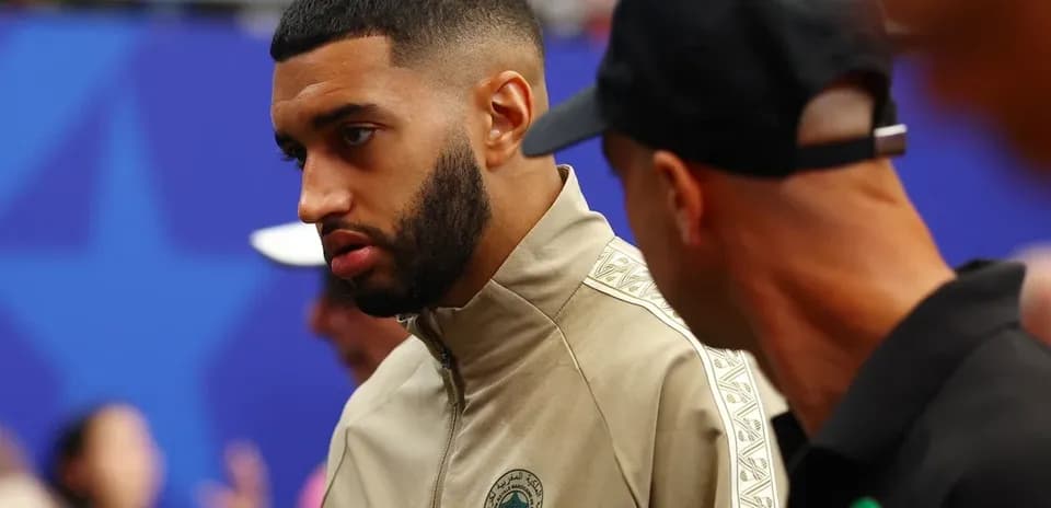 Player in Morocco tracksuit talking with teammate