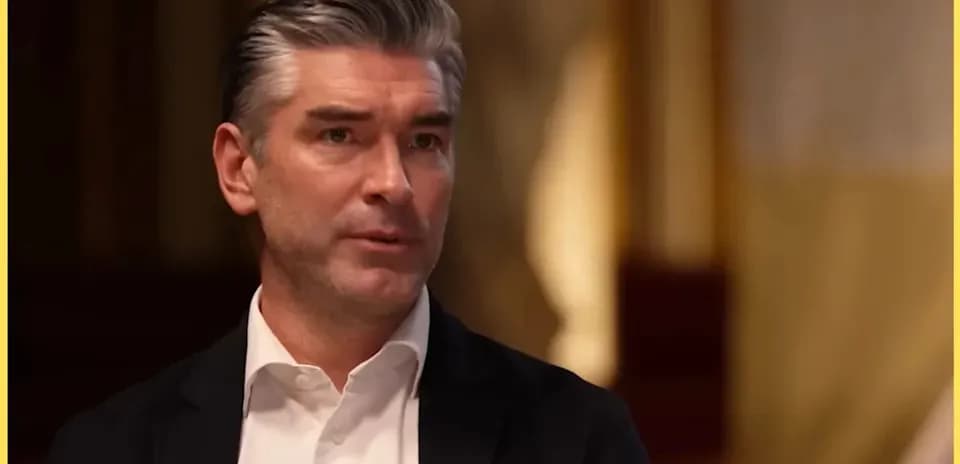 Man speaking during an interview in formal attire