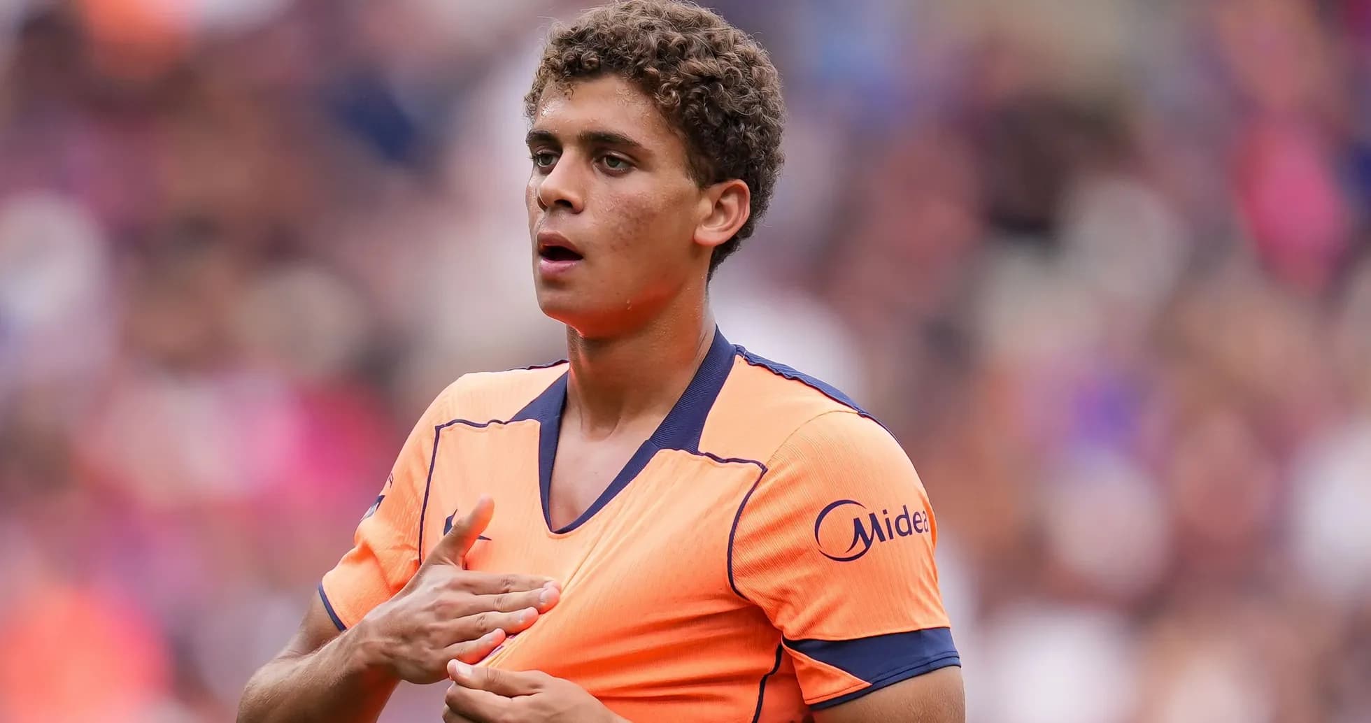 Player in orange jersey during match preparation