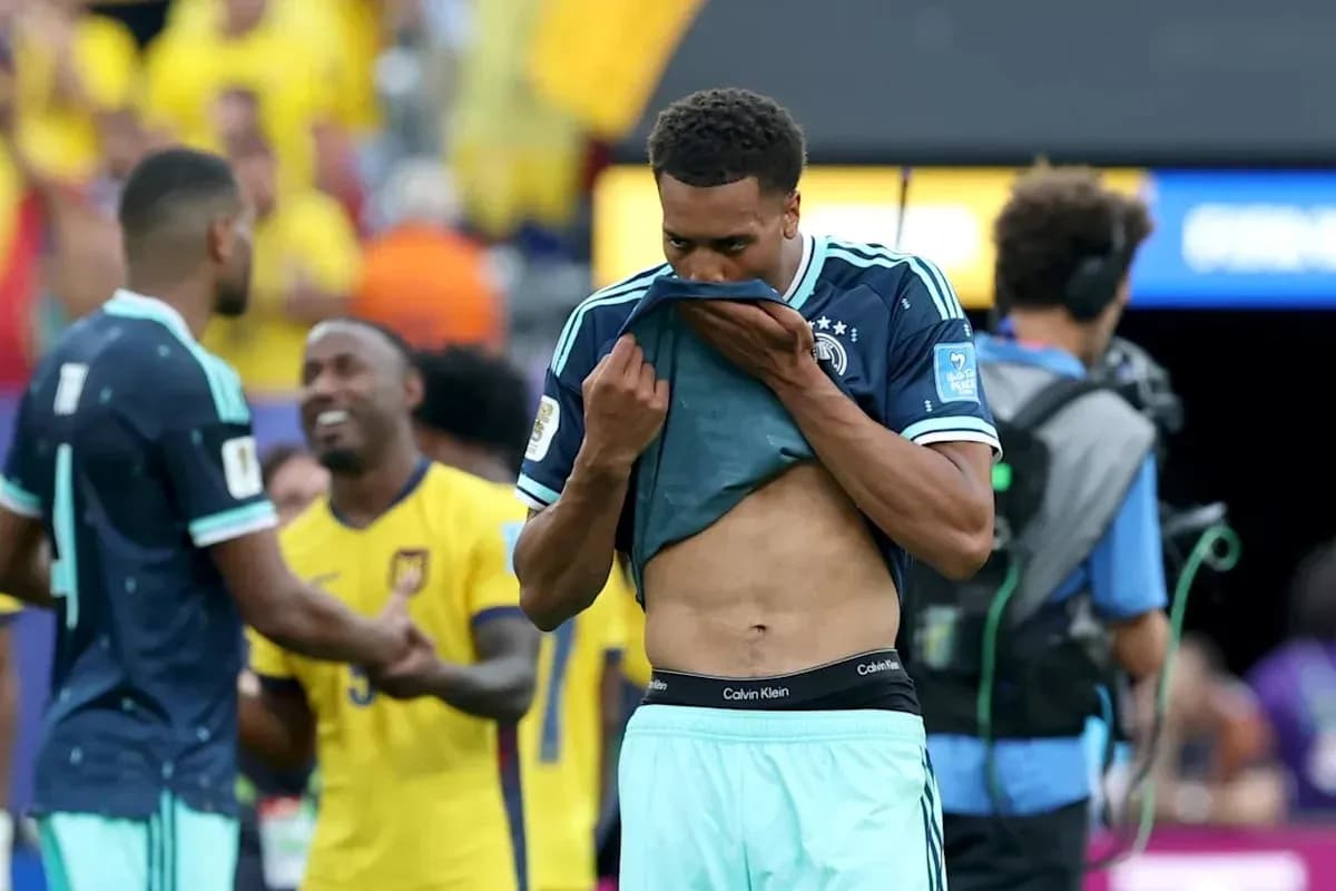 Player removing shirt after match, teammates celebrating
