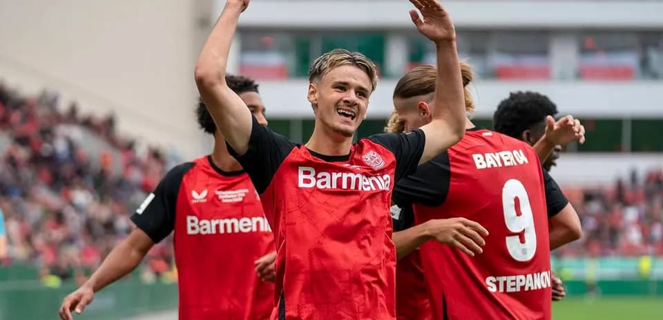 Player celebrating with teammates after scoring a goal