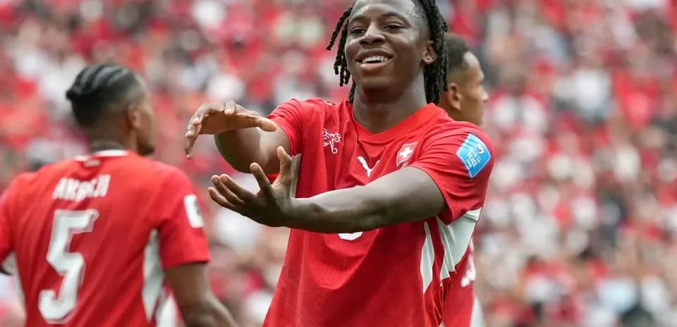 Player celebrating with teammates in red jerseys
