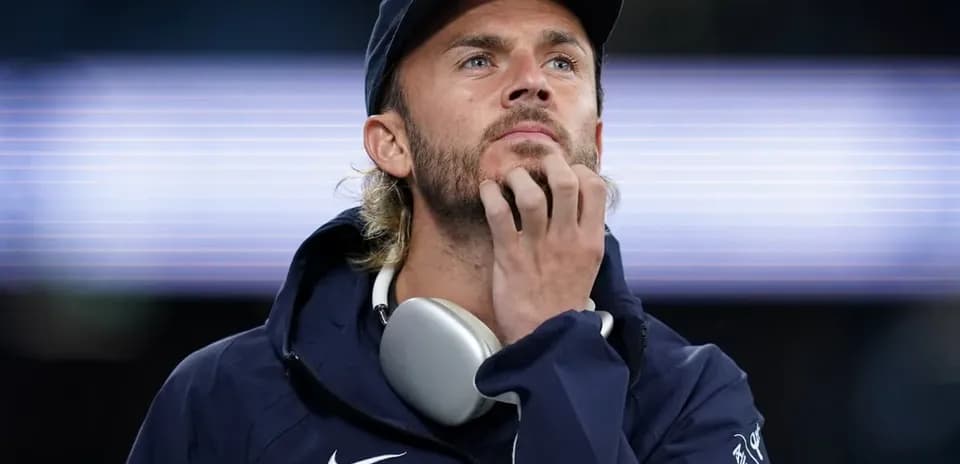 Man with headphones contemplating at stadium