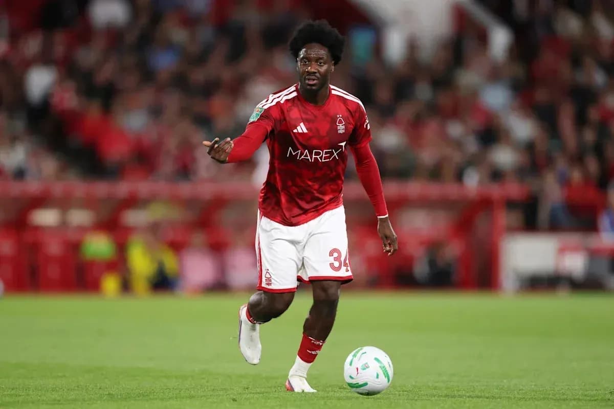 Player in red kit dribbling ball on field