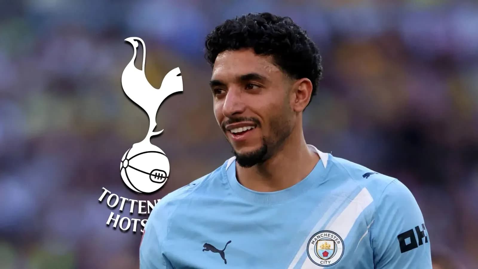 Player smiling in Manchester City kit with Tottenham logo
