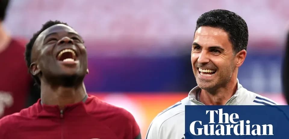 Two Arsenal members smiling and laughing together