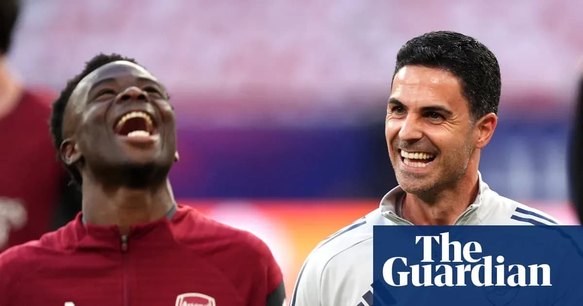 Two Arsenal members smiling and laughing together