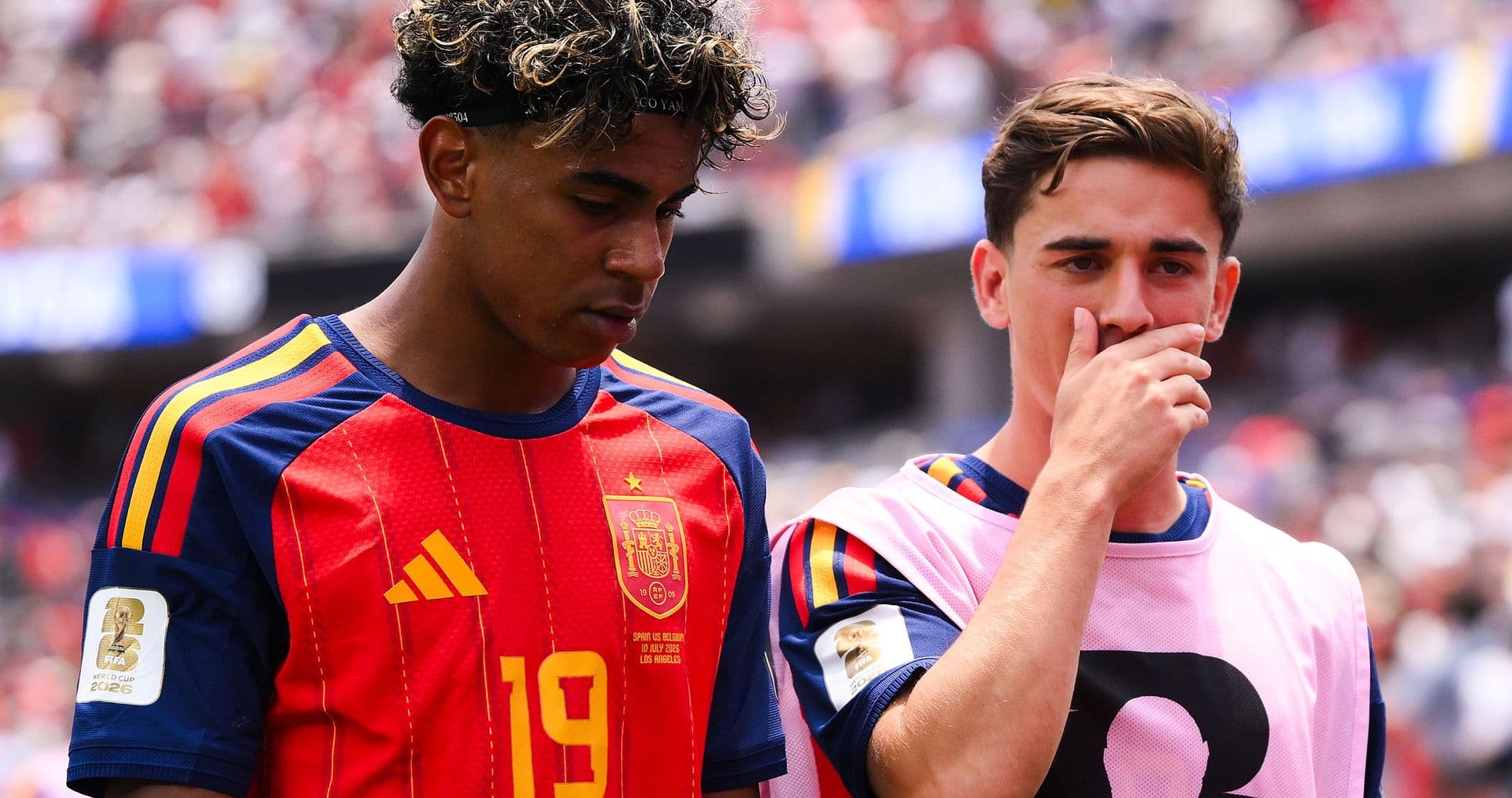 Two Spain players discussing on the sideline