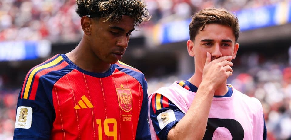 Two Spain players discussing on the sideline