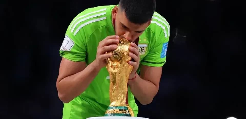 Goalkeeper kissing FIFA World Cup trophy on podium