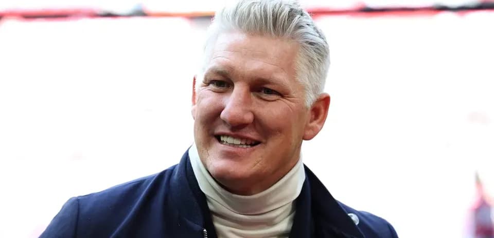 Smiling man in a navy jacket at stadium