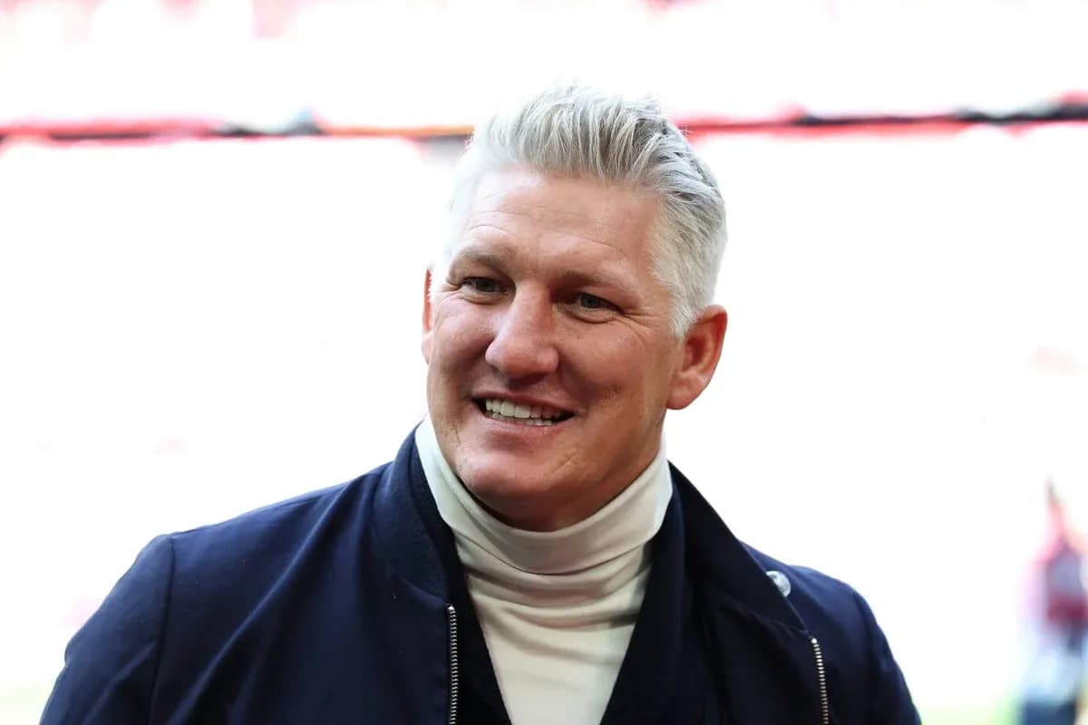 Smiling man in a navy jacket at stadium