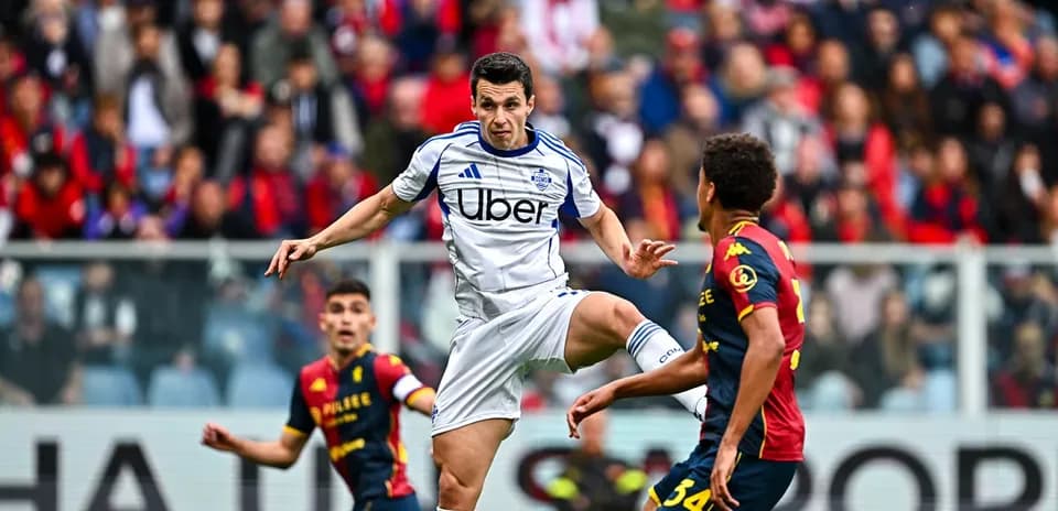 Genoa player challenging Como player for ball
