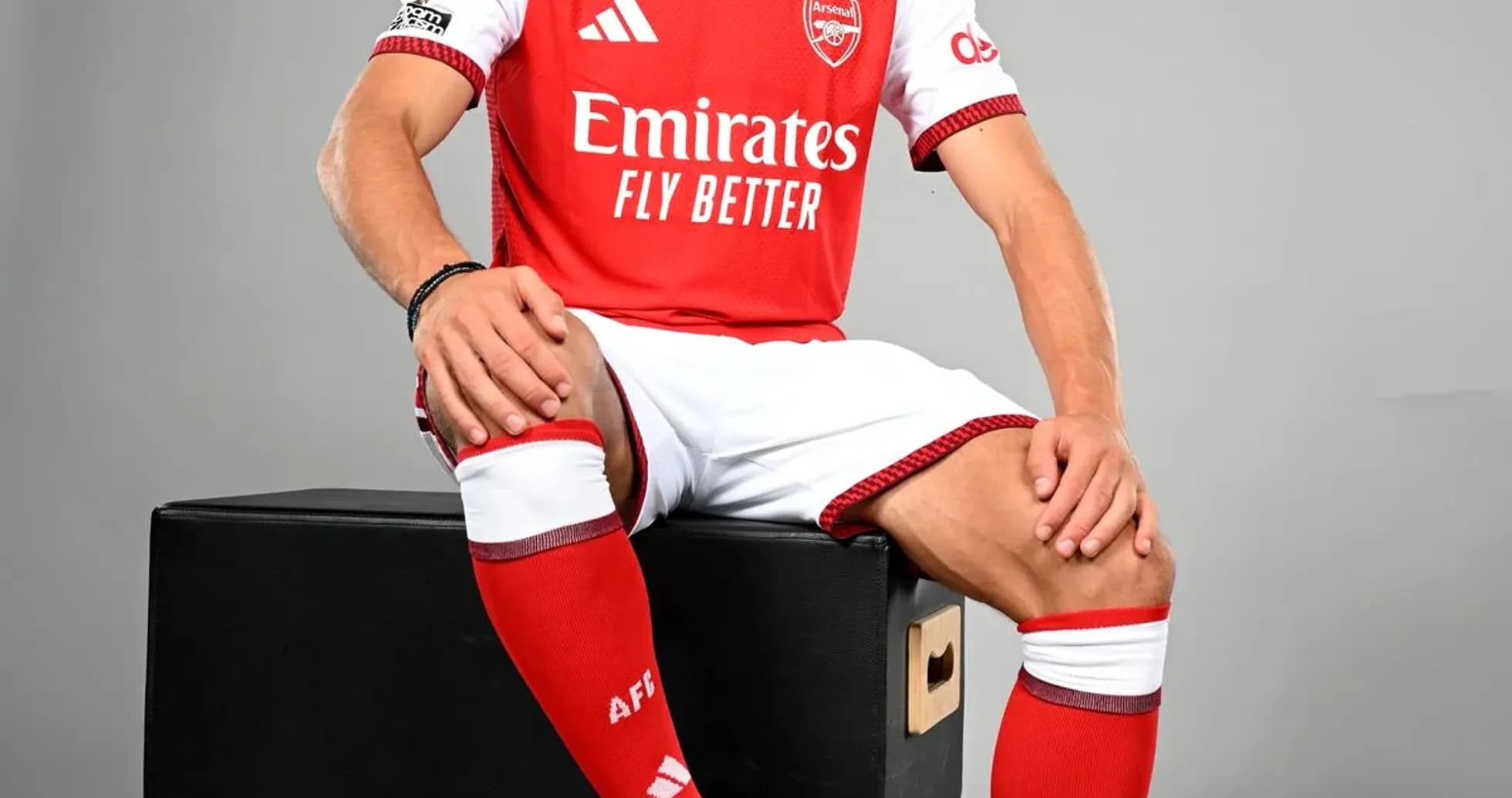 Player in Arsenal kit posing with a football