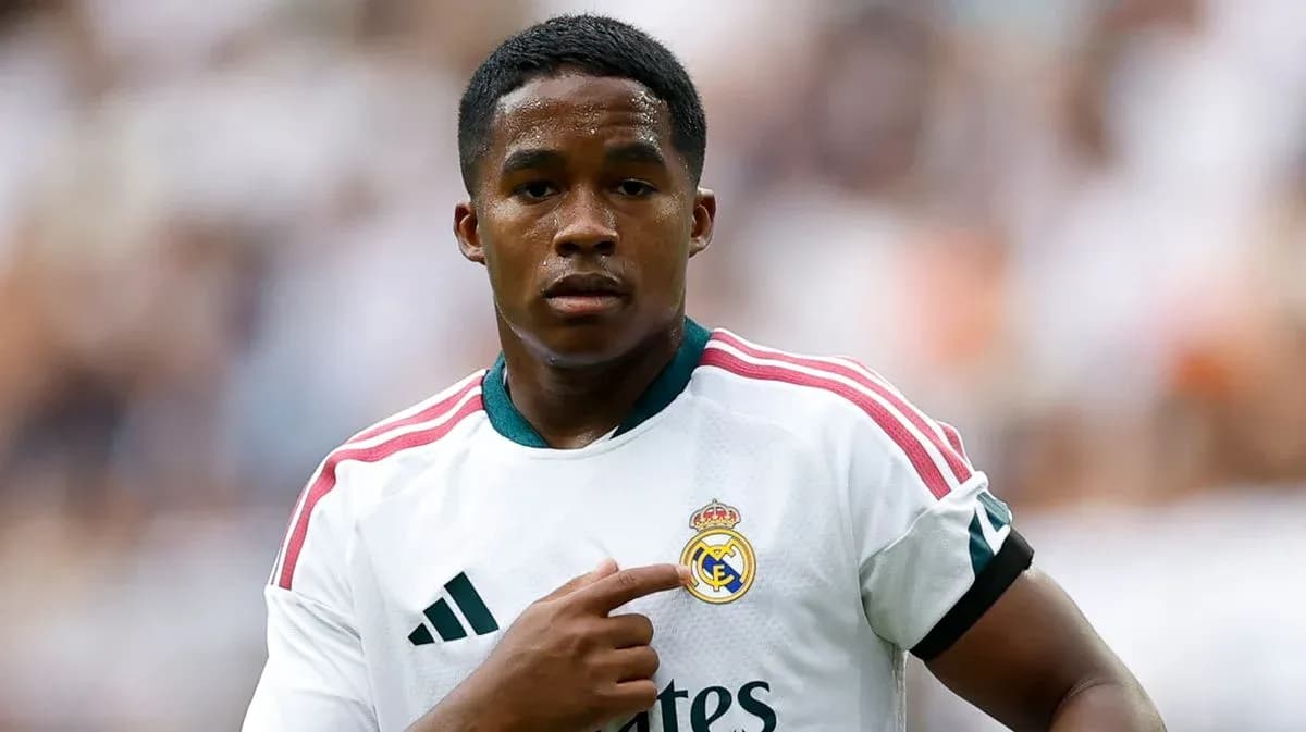 Player pointing at Real Madrid badge on jersey