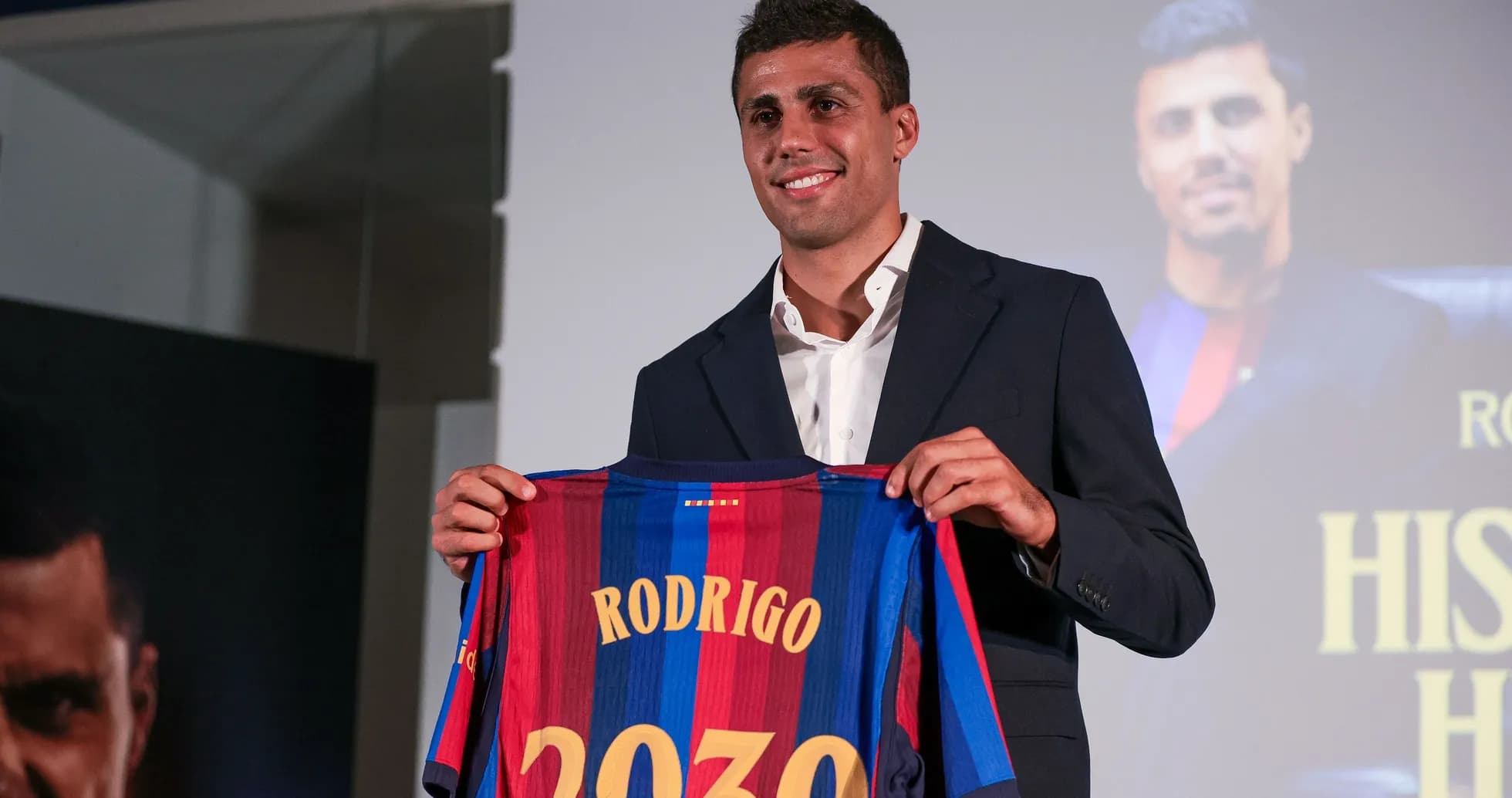 Player holding a Barcelona jersey at presentation event