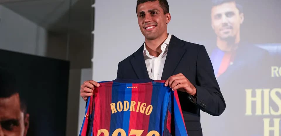 Player holding a Barcelona jersey at presentation event