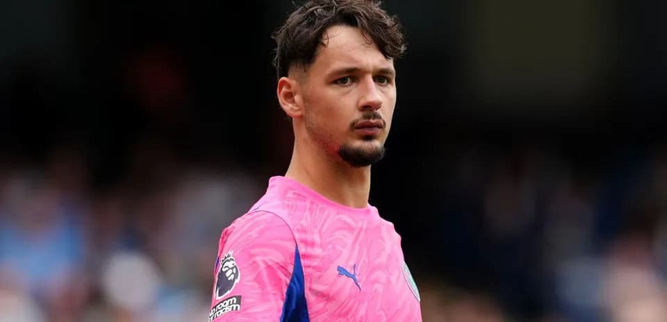 Goalkeeper in pink kit during match warm-up